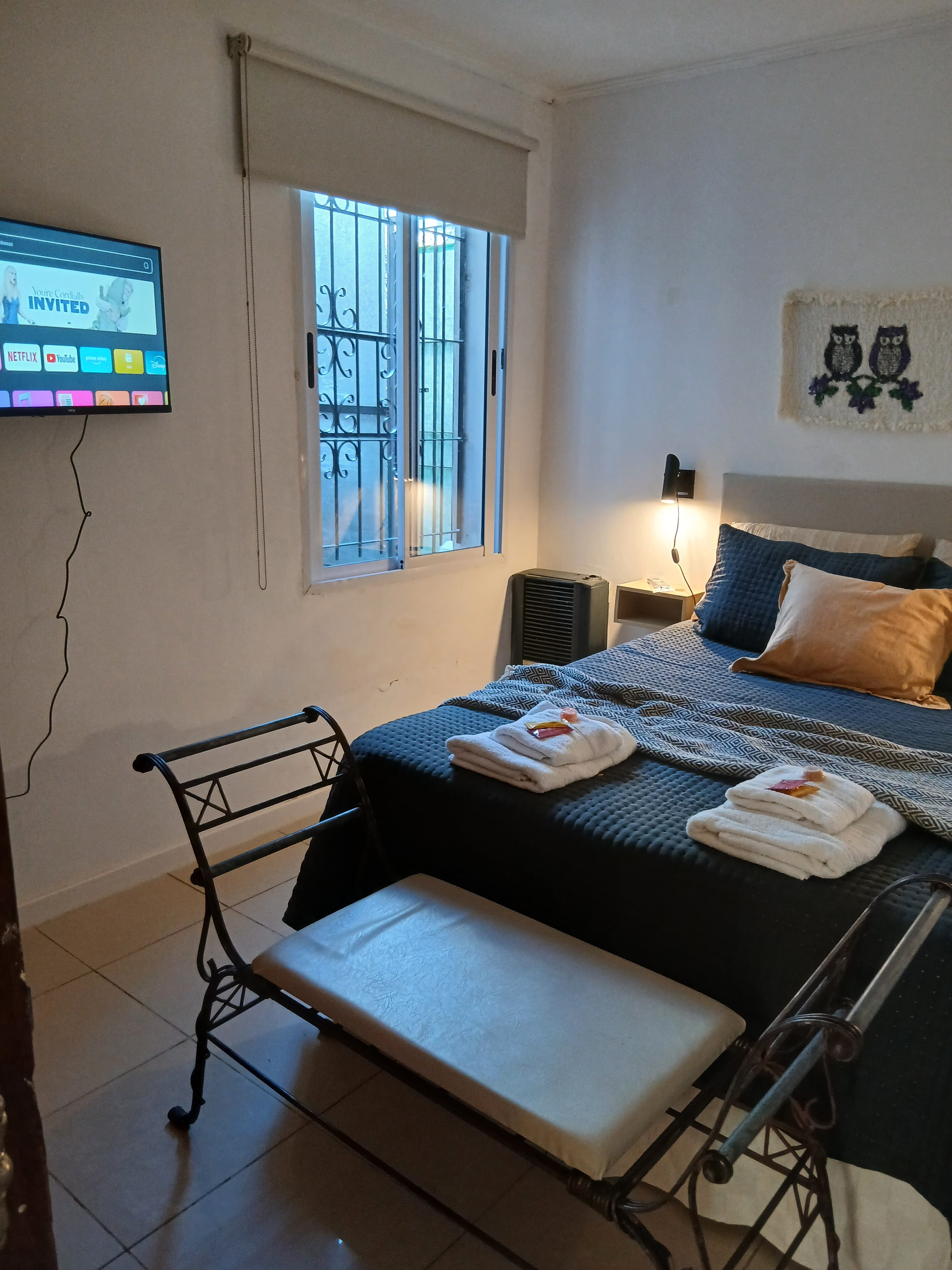 Dormitorio con cama y Smart TV montada en la pared