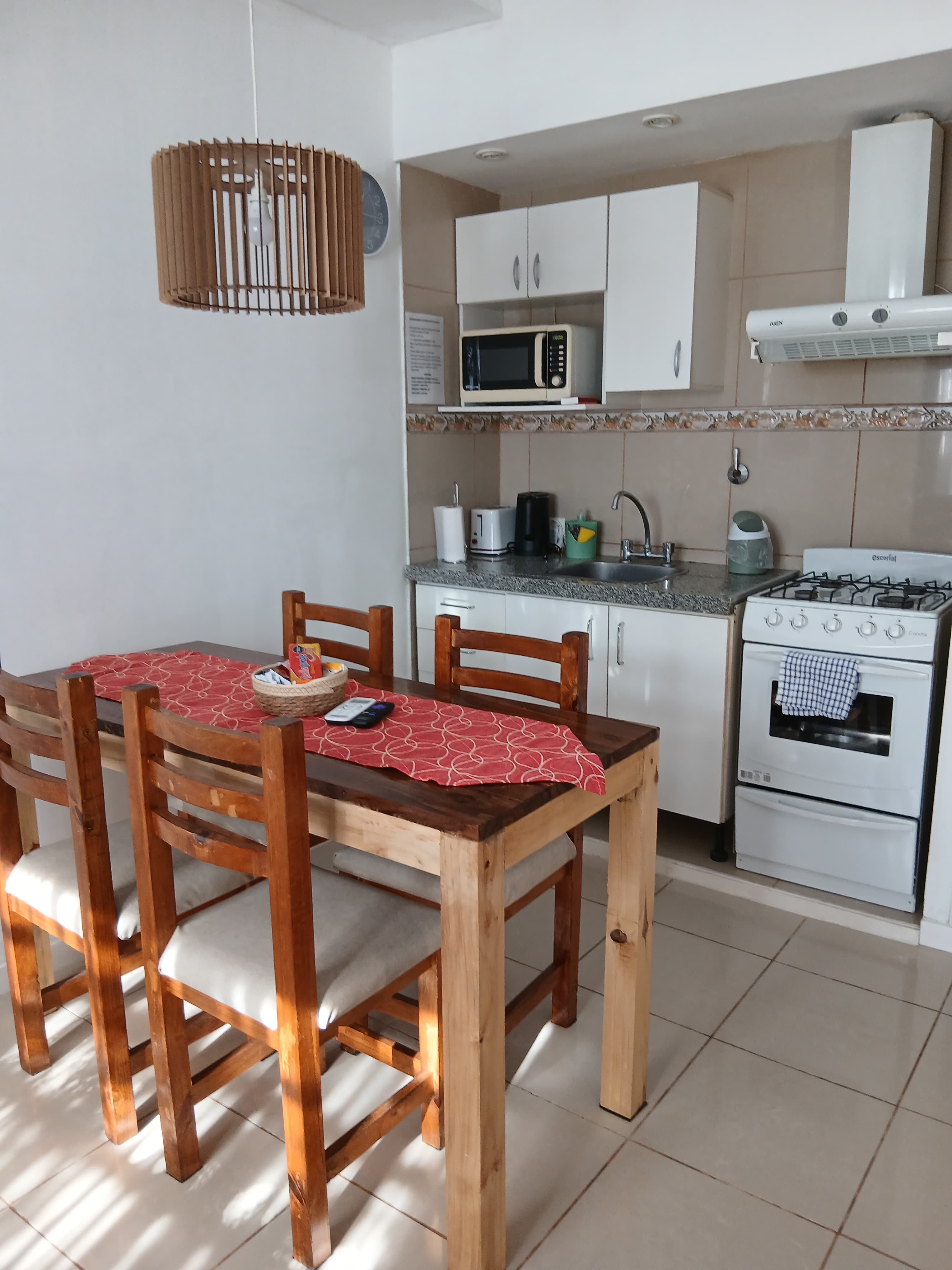 Cocina equipada y comedor con mesa para cuatro personas